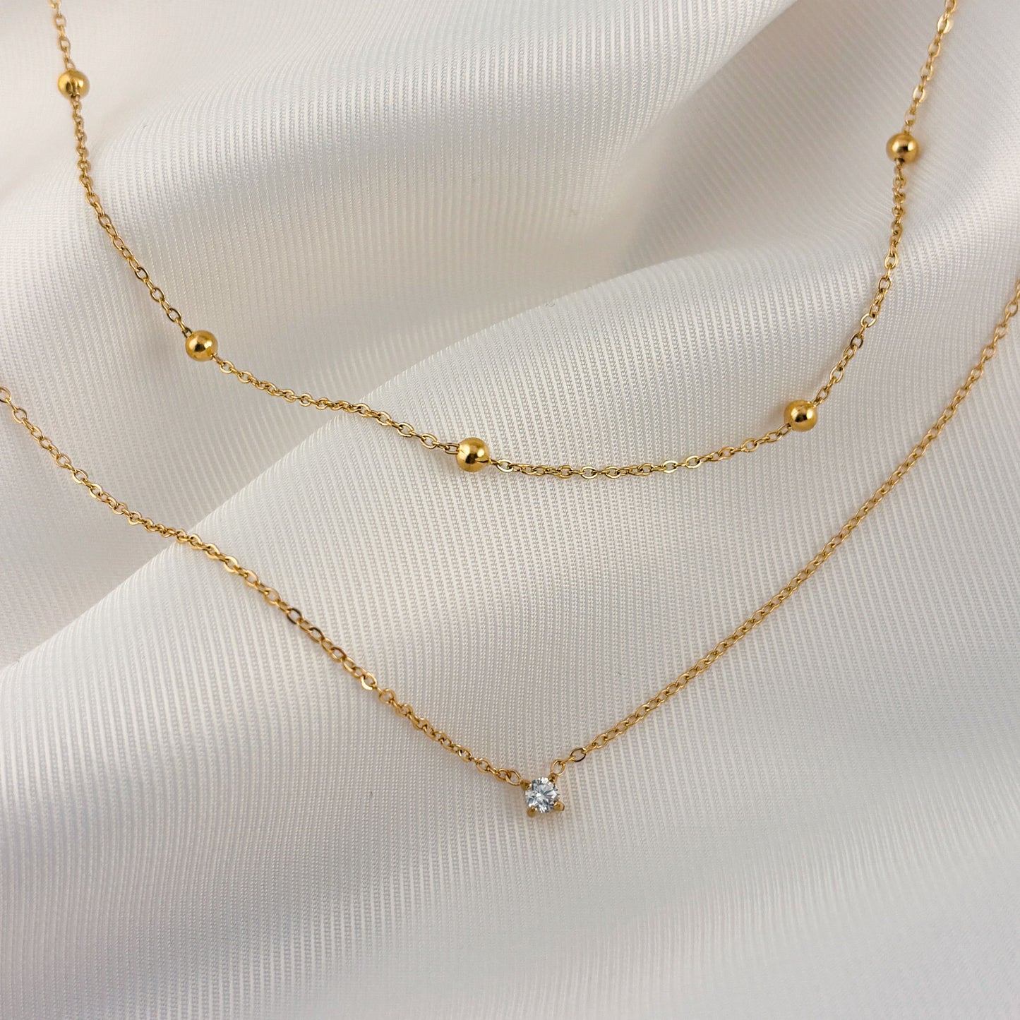 Collar doble acero inoxidable bolitas y zirconia dorado