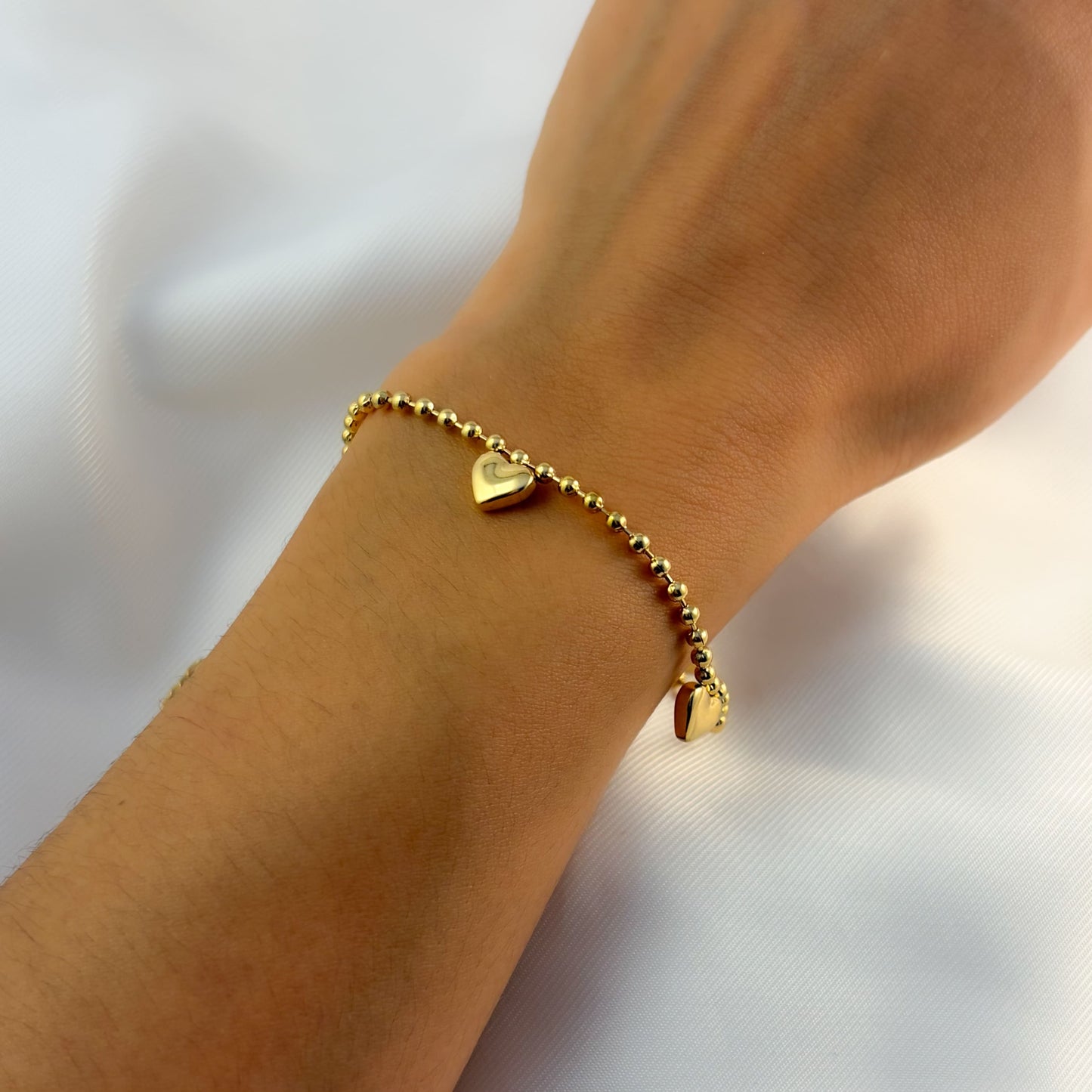 Pulsera acero inoxidable bolitas 3 corazones globo dorado