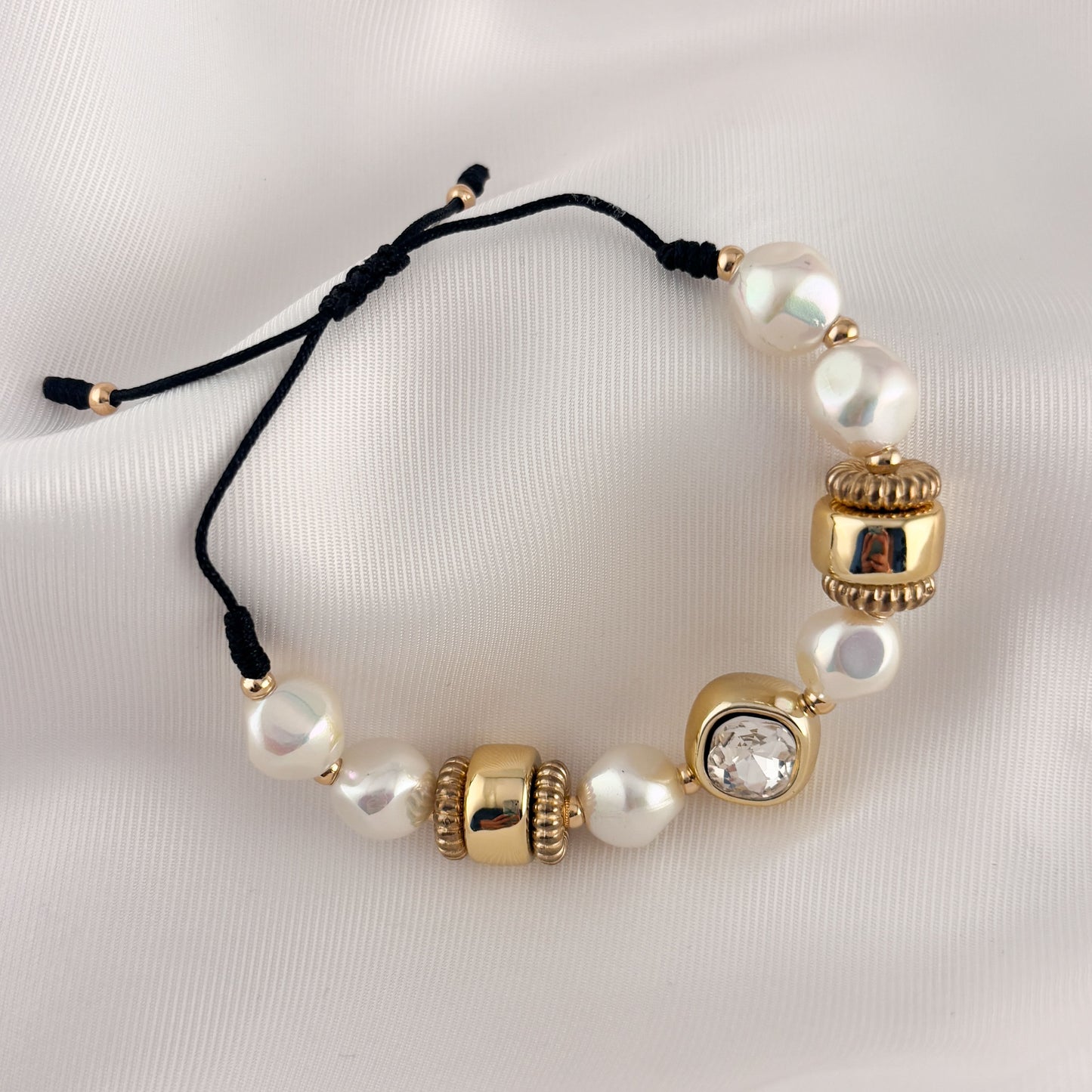 Pulsera perlas ruedas cordón negro chapa de oro