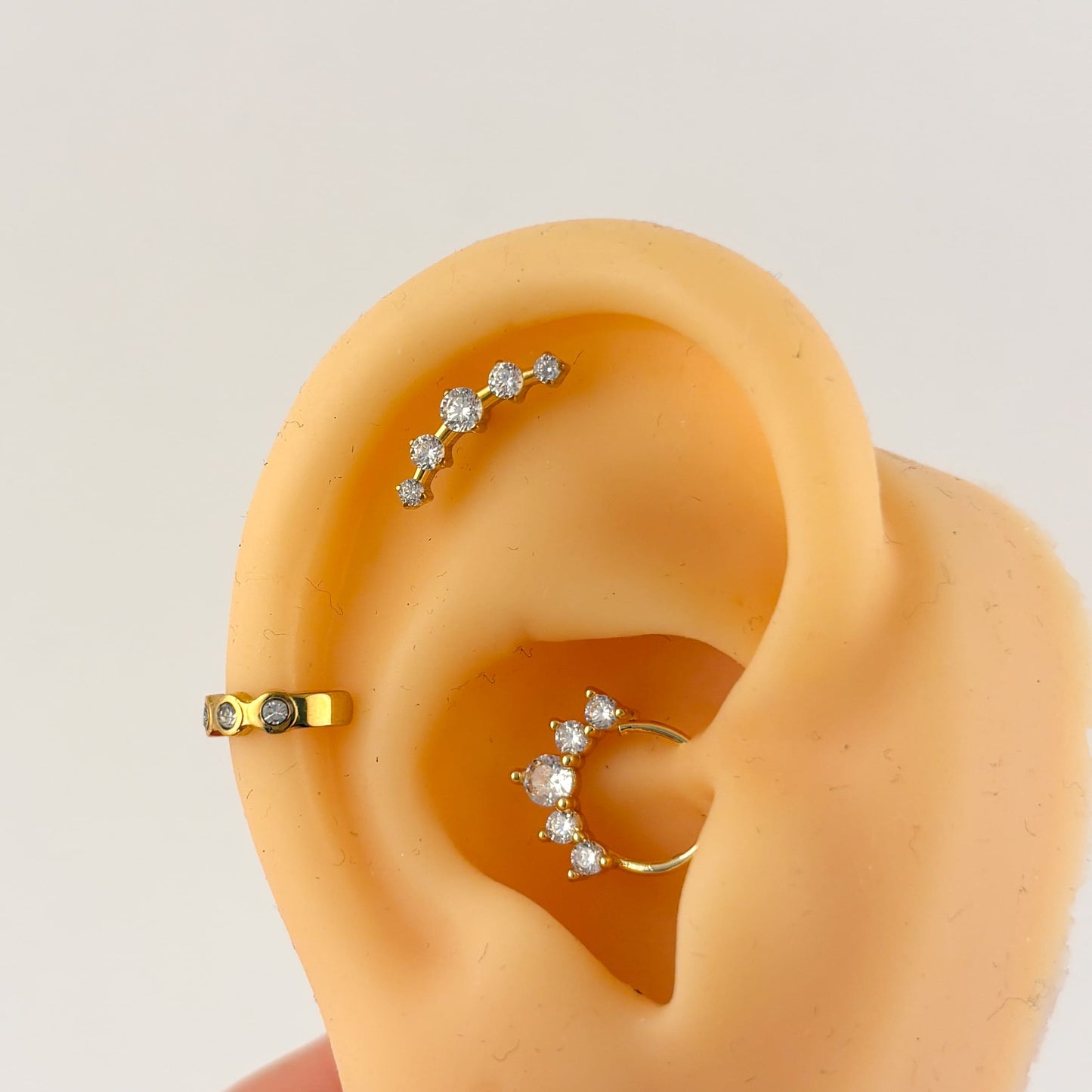 Piercing acero quirúrgico dorado curva 5 zirconias