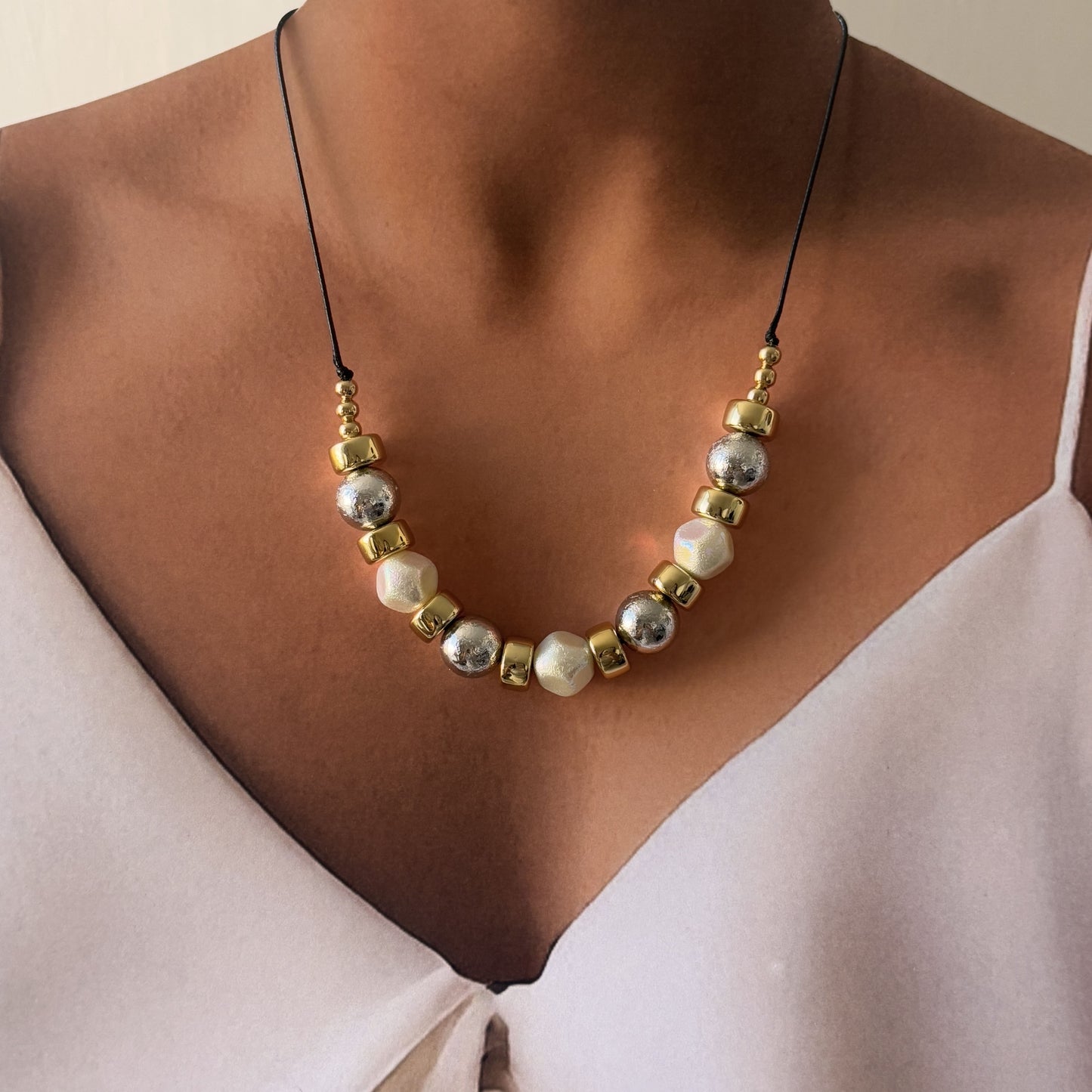 Collar chapa de oro ruedas y bola bicolor cordón negro