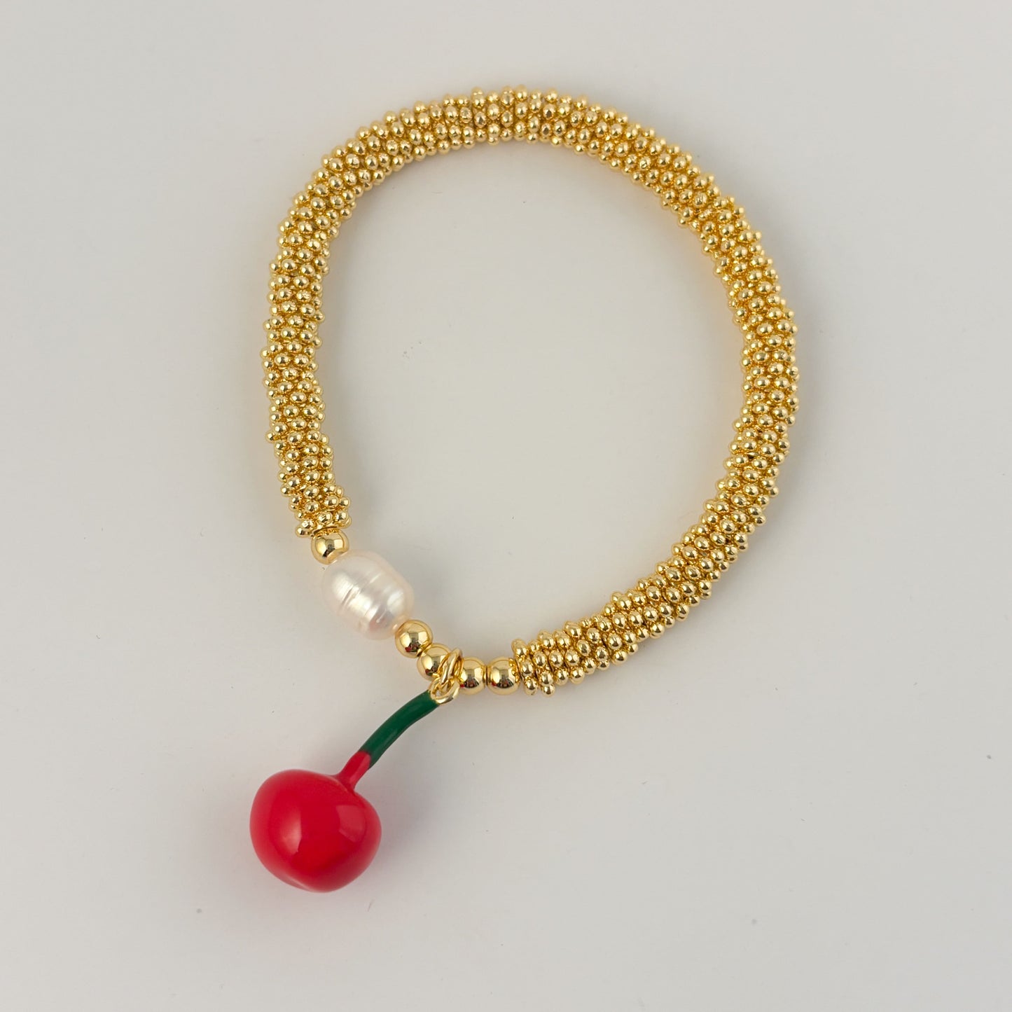 Pulsera rueditas perla y dije Corazón rojo o caracol chapa de oro