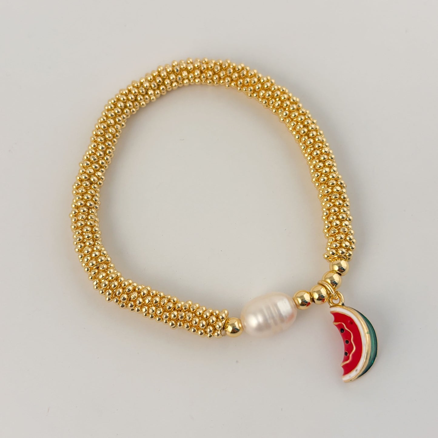 Pulsera rueditas perla y dije Corazón rojo o caracol chapa de oro