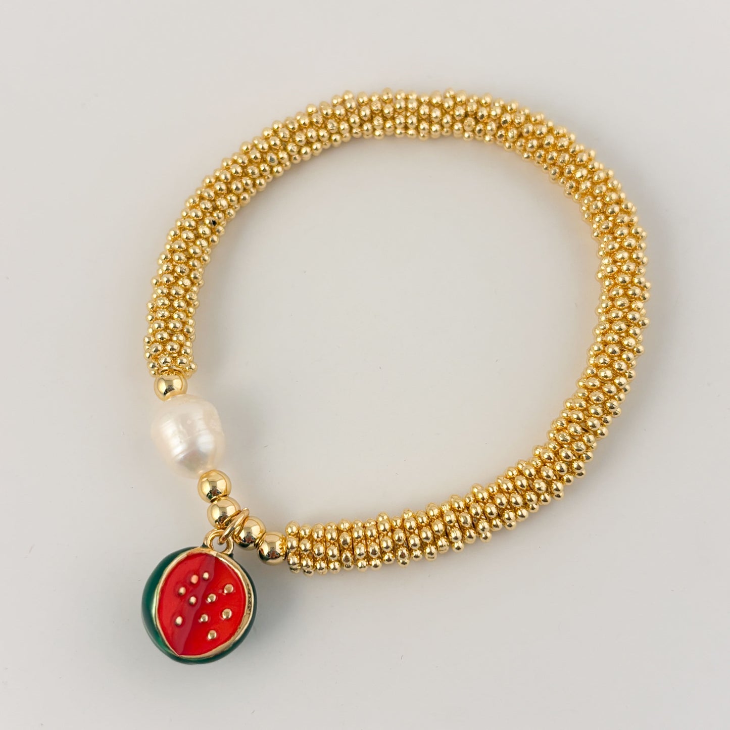 Pulsera rueditas perla y dije Corazón rojo o caracol chapa de oro