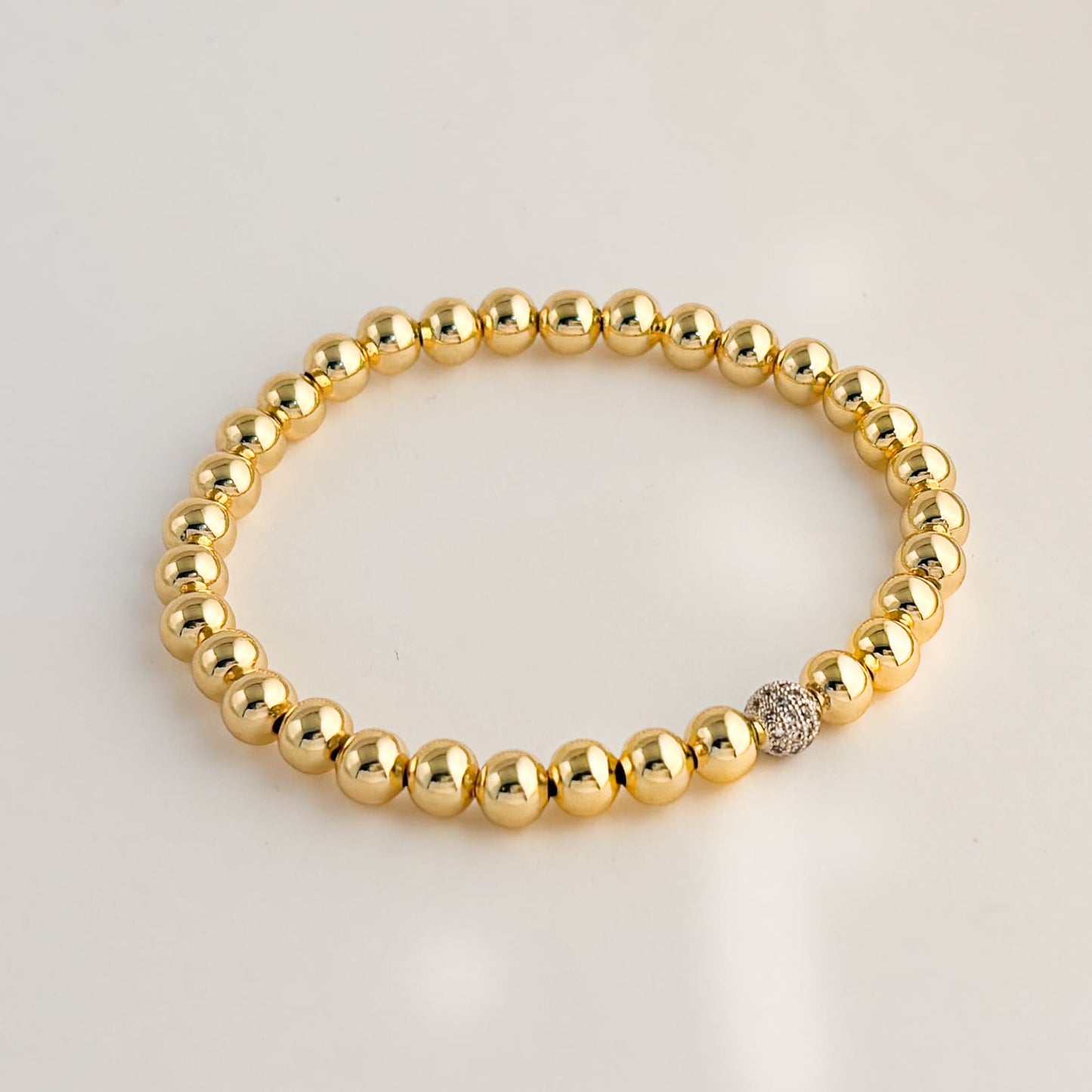 Pulsera bolitas eslástico esfera plateada zirconias chapa de oro