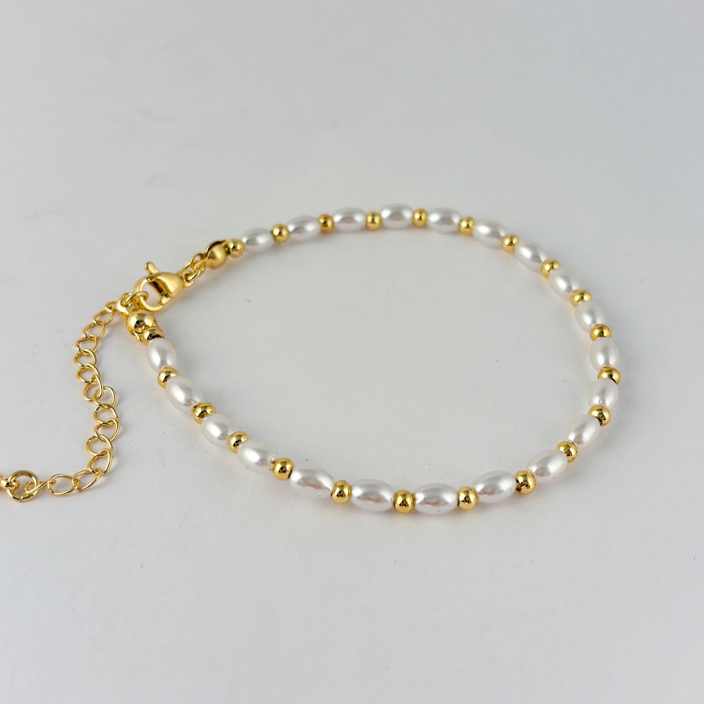 Pulsera perlas semilla con bolita chapa de oro