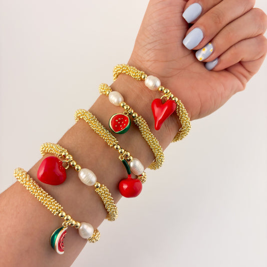 Pulsera rueditas perla y dije Corazón rojo o caracol chapa de oro