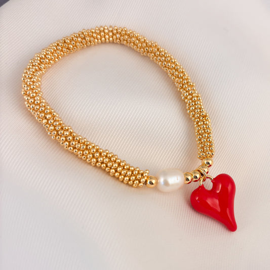 Pulsera rueditas perla y dije Corazón rojo o caracol chapa de oro
