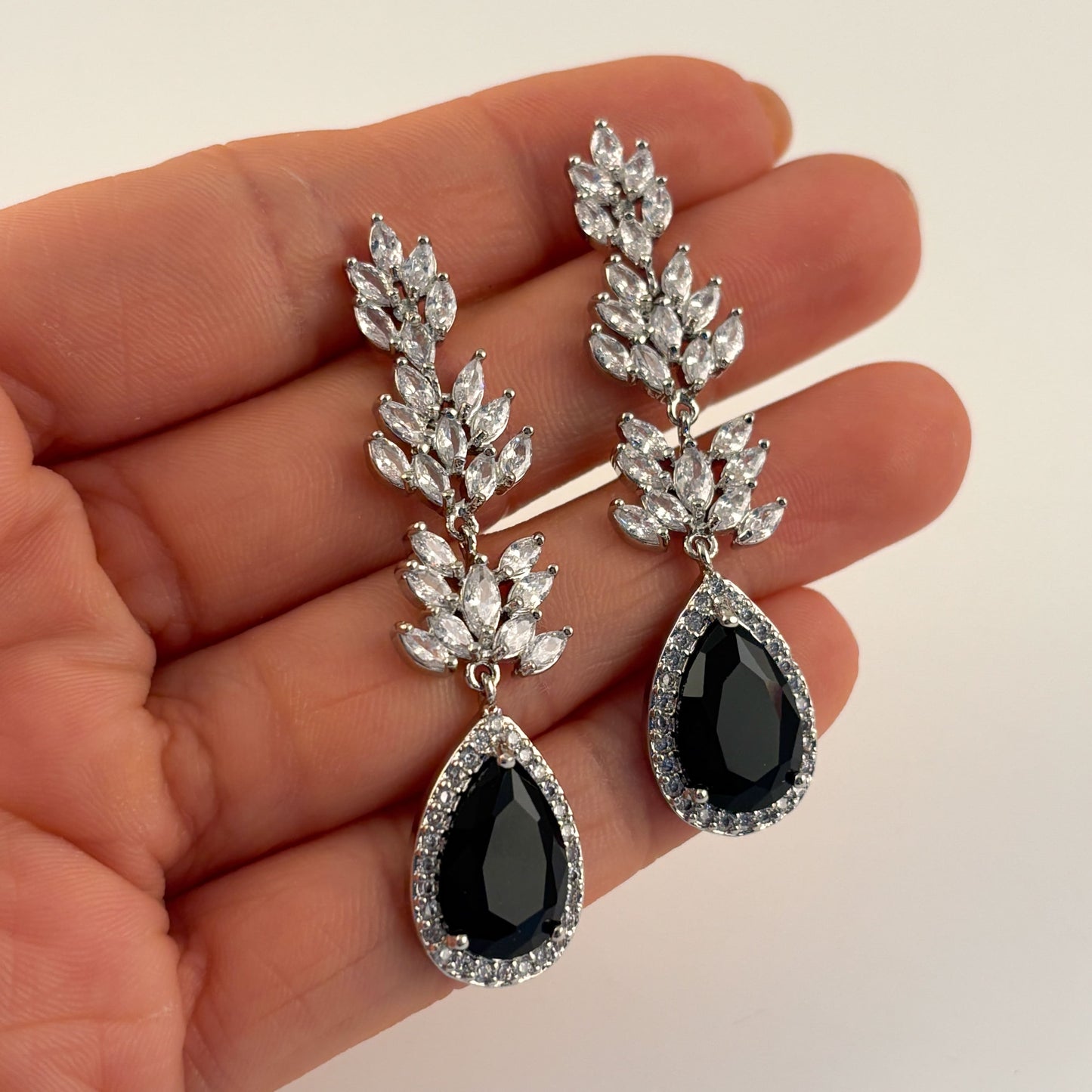 Aretes largos plateados cristal negro hojas baño de oro