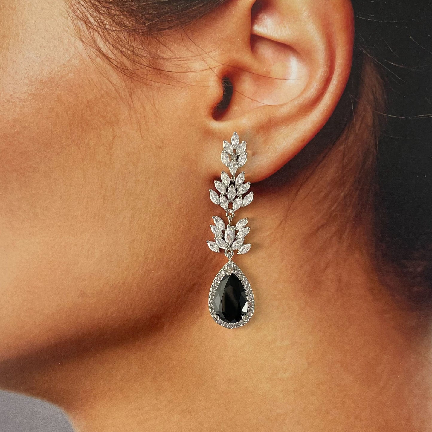 Aretes largos plateados cristal negro hojas baño de oro