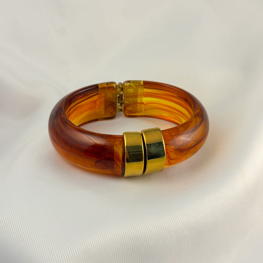 Brazalete de acrilico ambar punta dorado acero