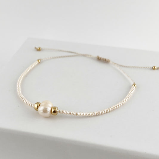 Pulsera hilo con chaquira color beige y perla natural
